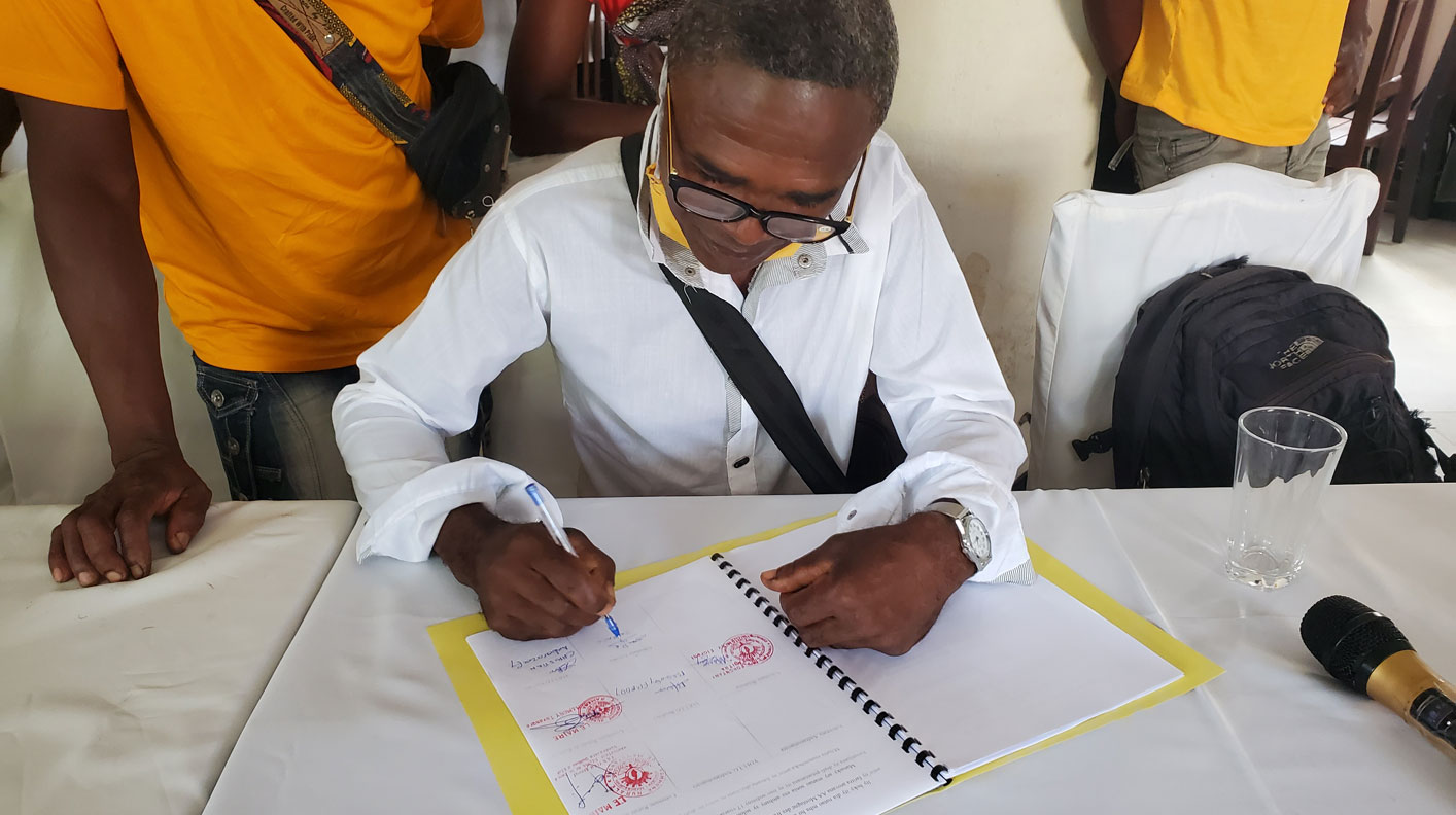 Village leader signing an agreement