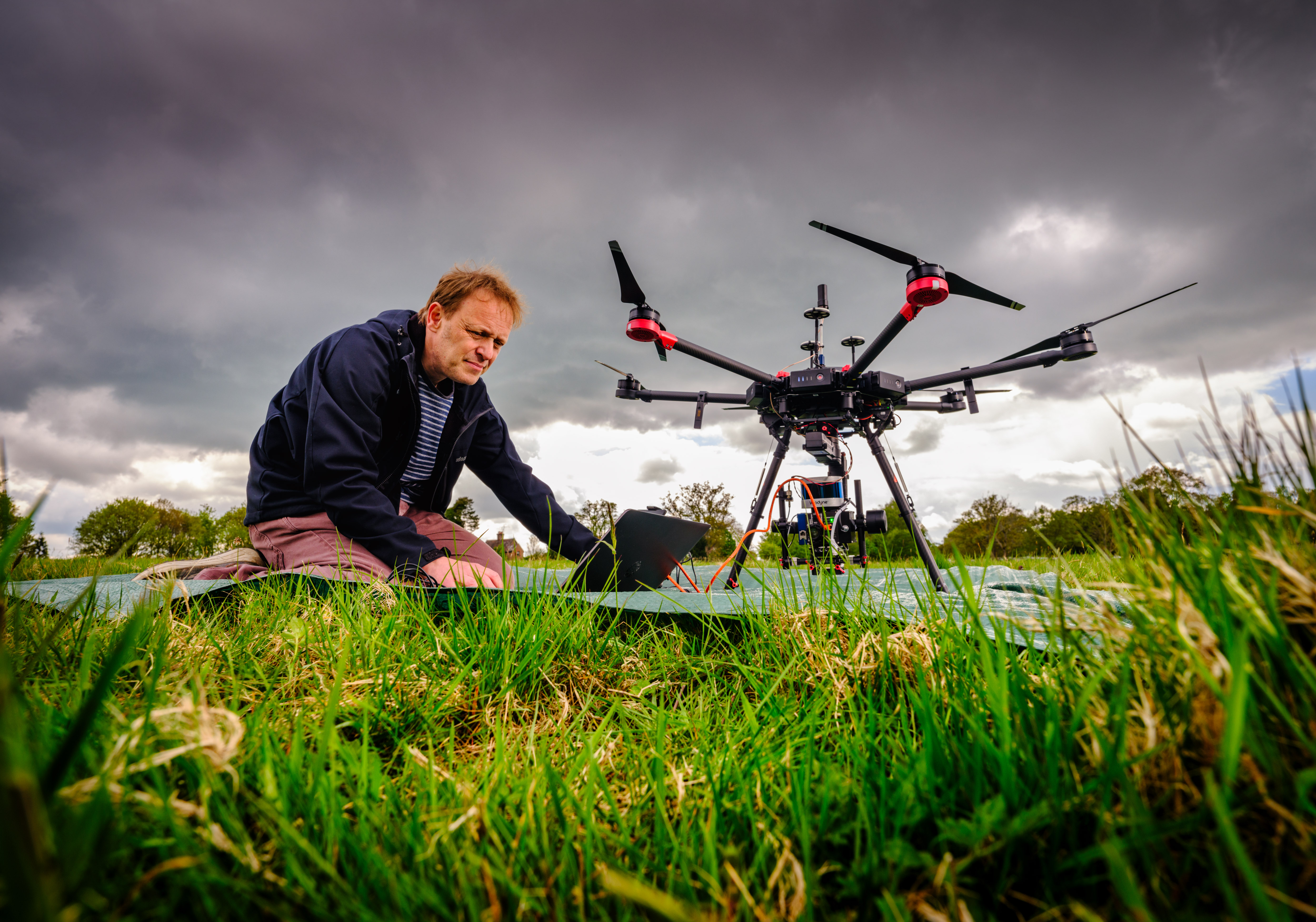 Kew scientist kneeling down with a drone