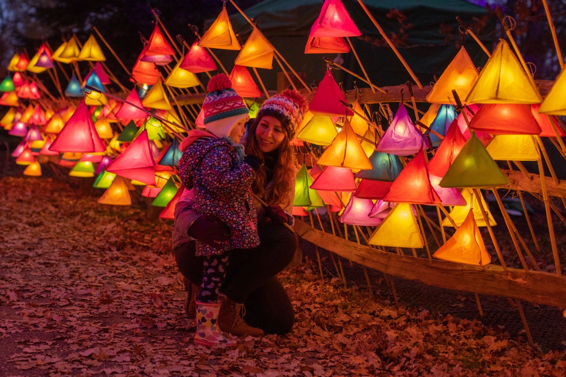 Mother and child enjoy glow of handheld lanterns