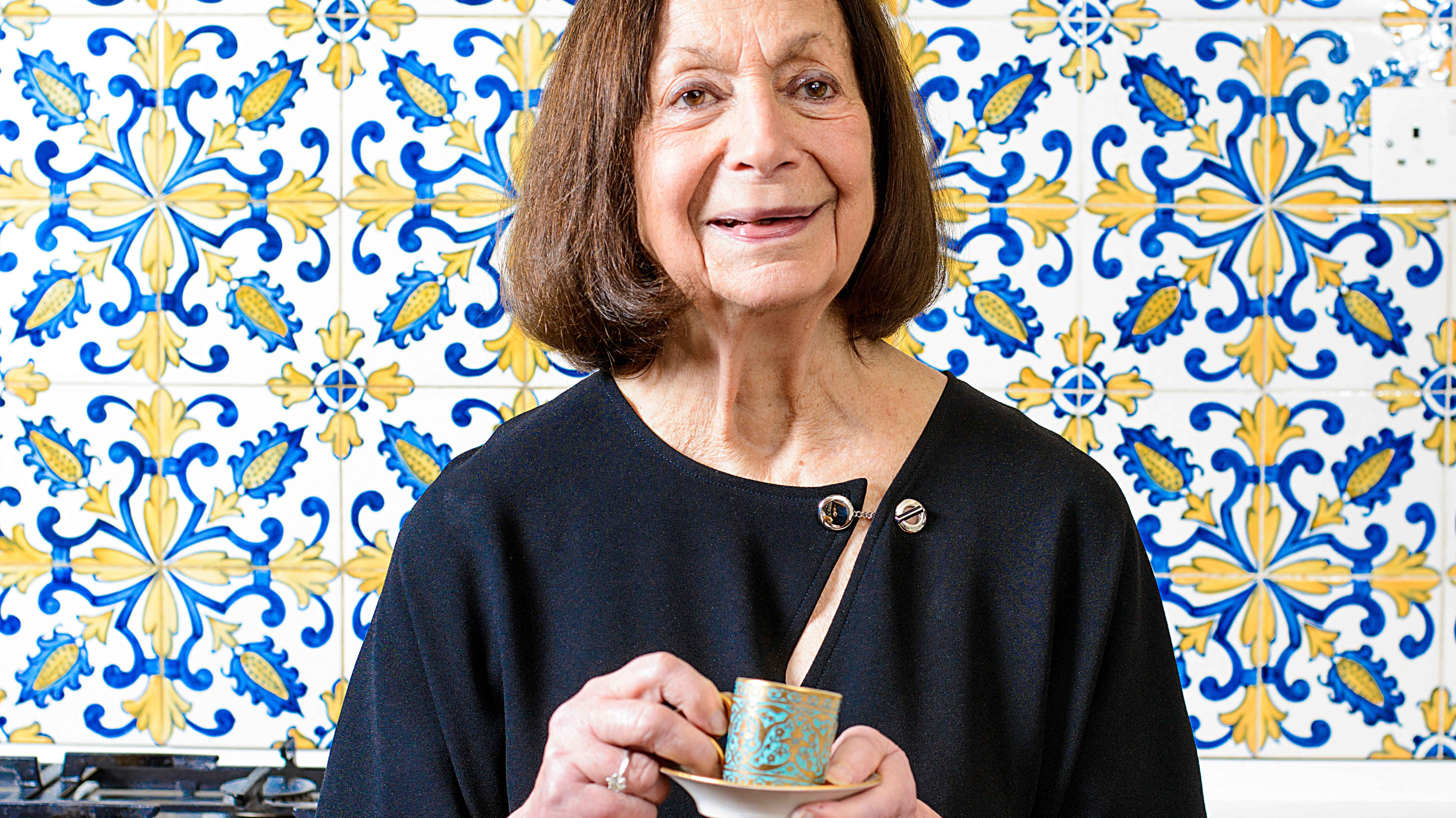 Claudia Roden with blue and yellow tiles behind her