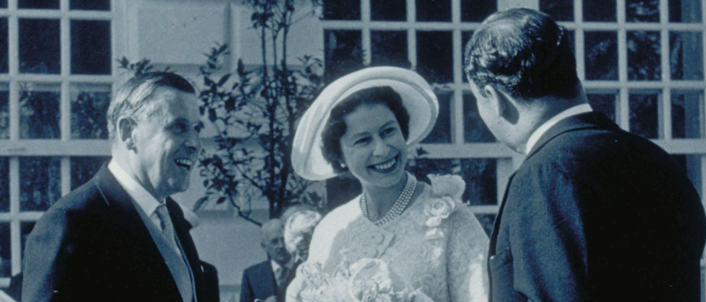 A black and white photo of Her Majesty outside Kew's Orangery building