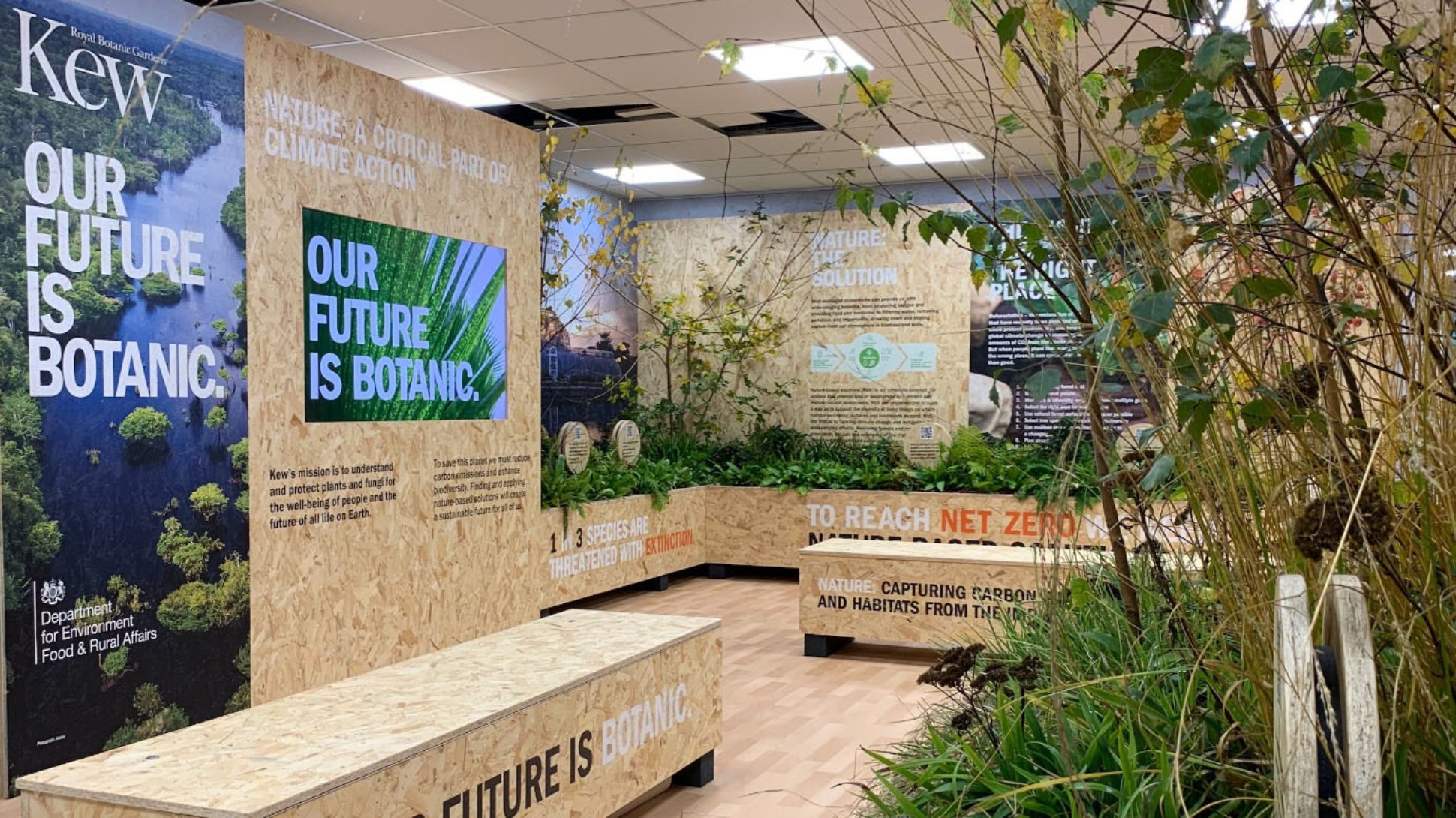 A booth made from wood with many plants and panels about the importance of plants in protecting against climate change