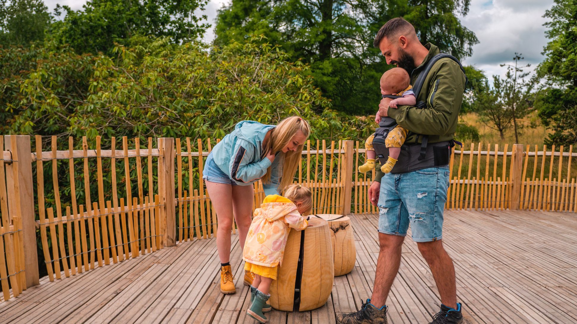 A family investigate wooden seats on a wooden decked viewing platform