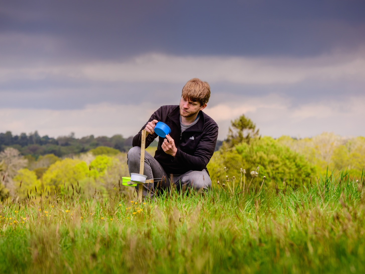 A researcher carrying out work on a research station in a grassy field