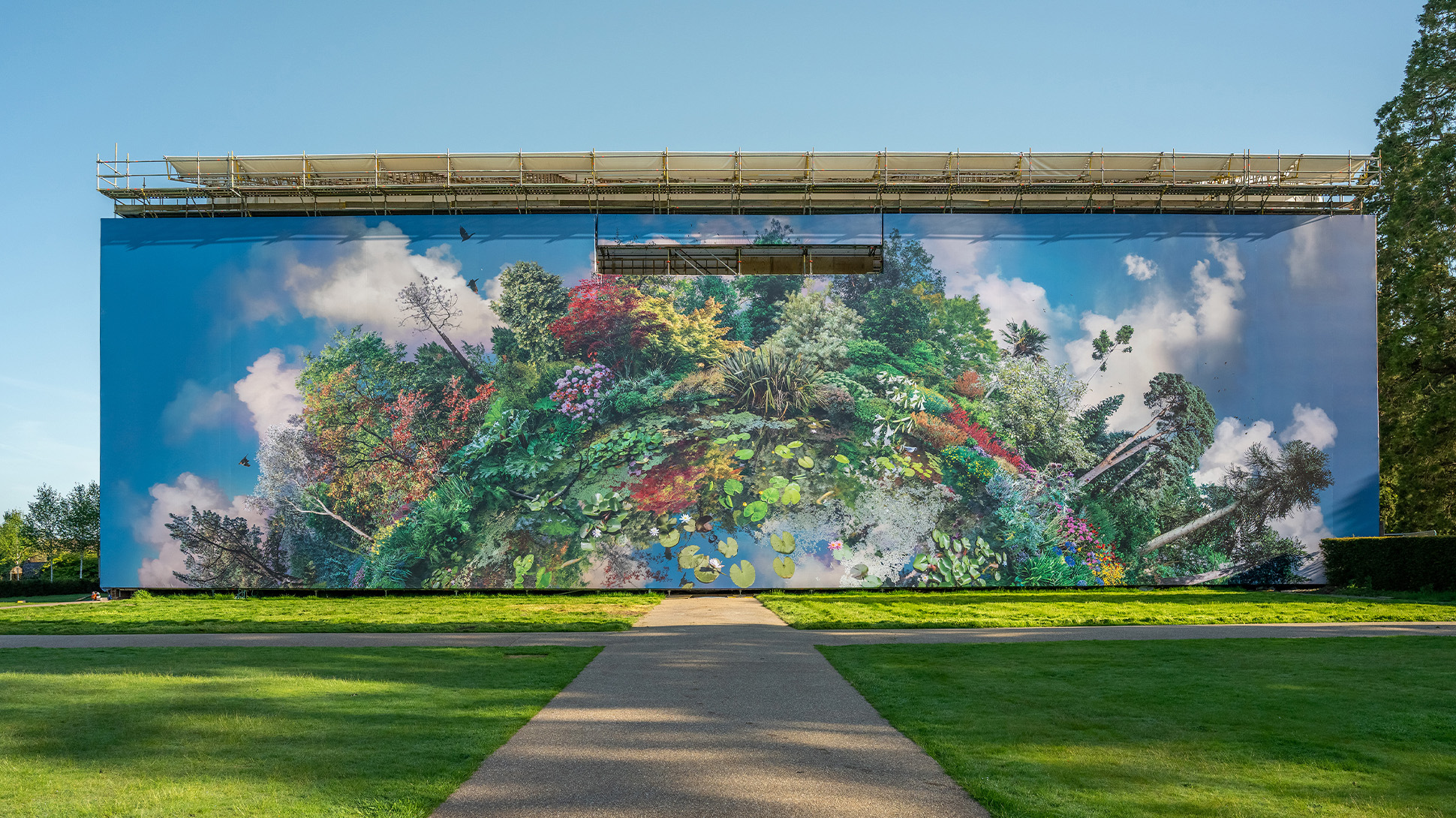 Giant artwork on the facade of a mansion, featuring a collage of plants and trees.