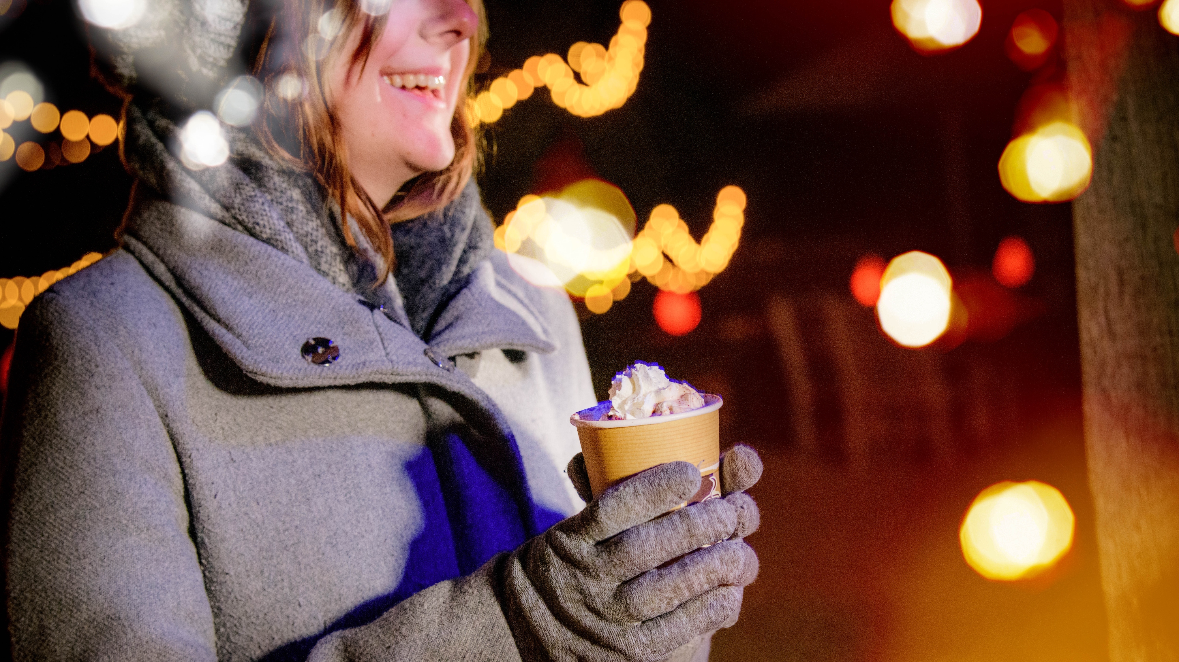 Person enjoying a warm hot chocolate at Glow Wild, Wakehurst
