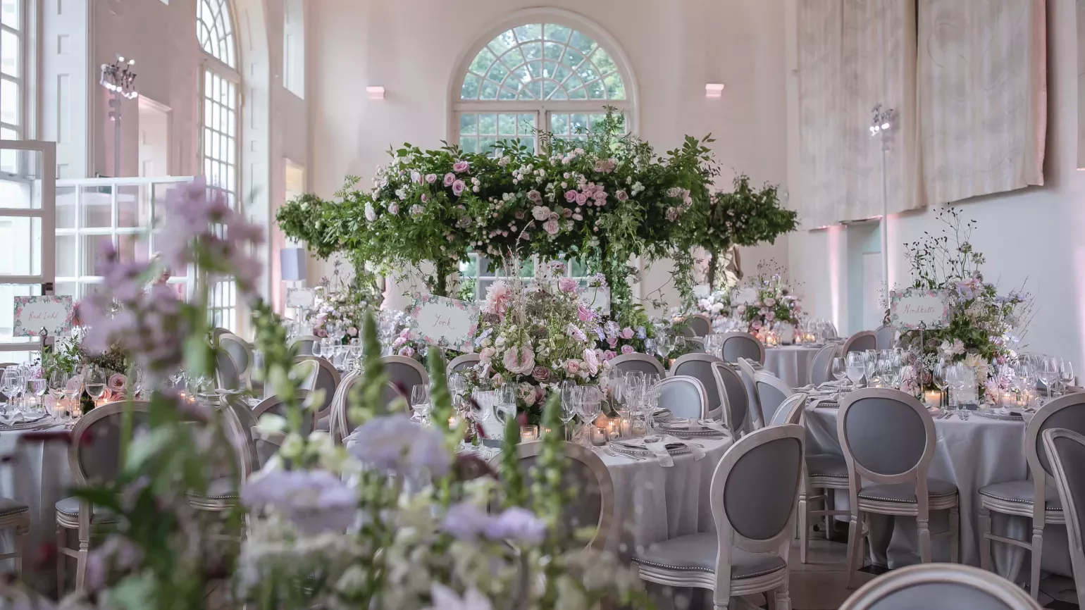 White chairs and tables decorated with white and pink flowers