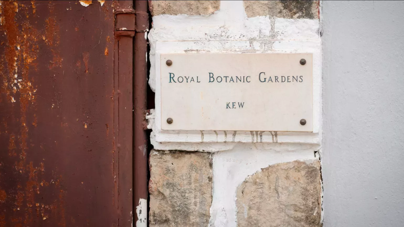A plaque on a building that reads Royal Botanic Gardens Kew