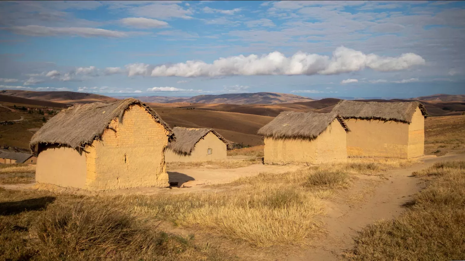 Small pale mud homes with thatched roofs.
