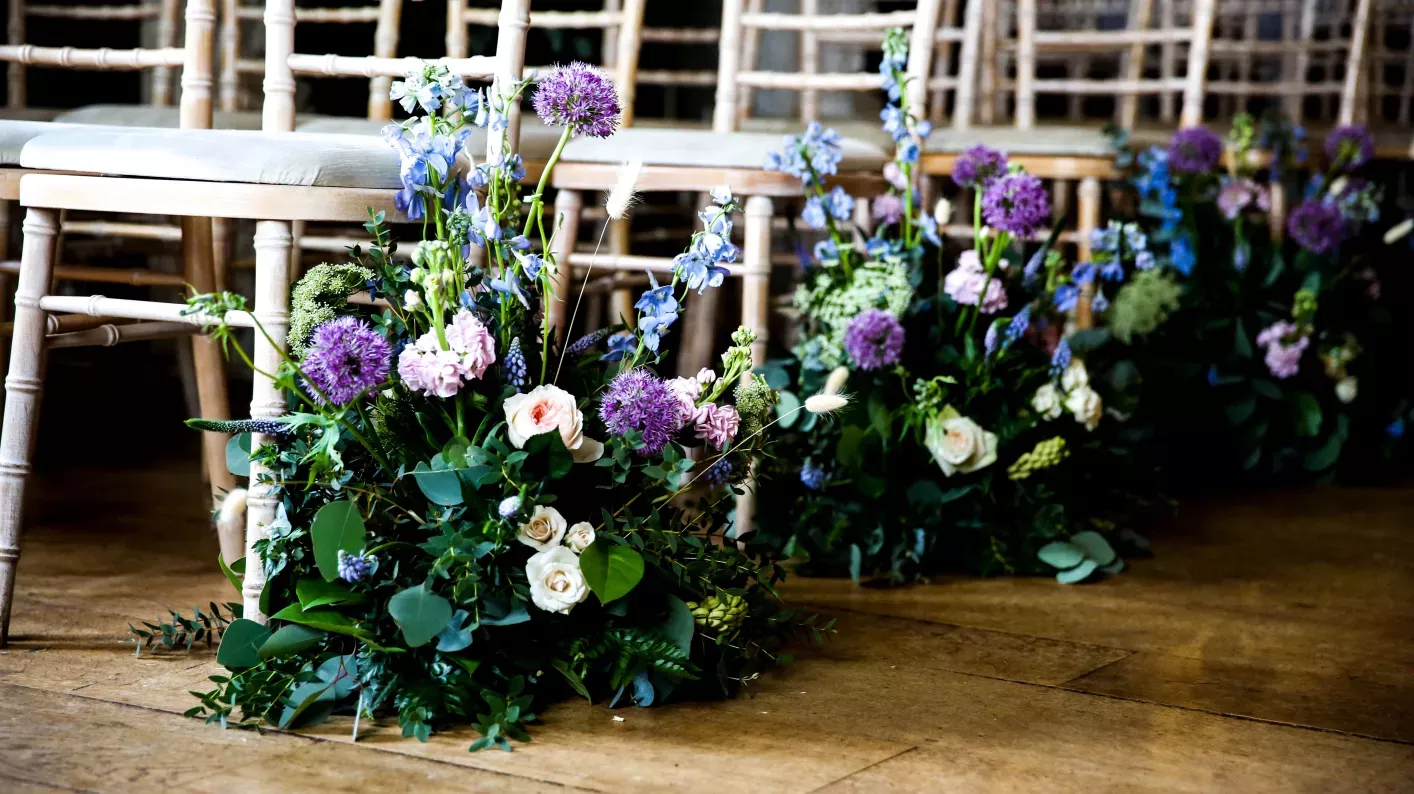 Pastel purple and white flowers on the end of aisles