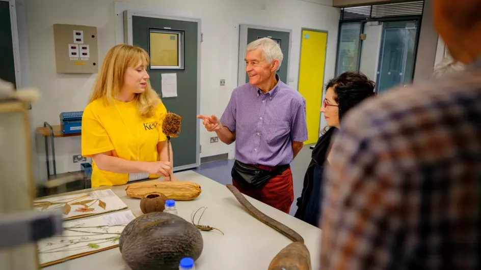 Staff in yellow t-shirts discuss their work with visitors