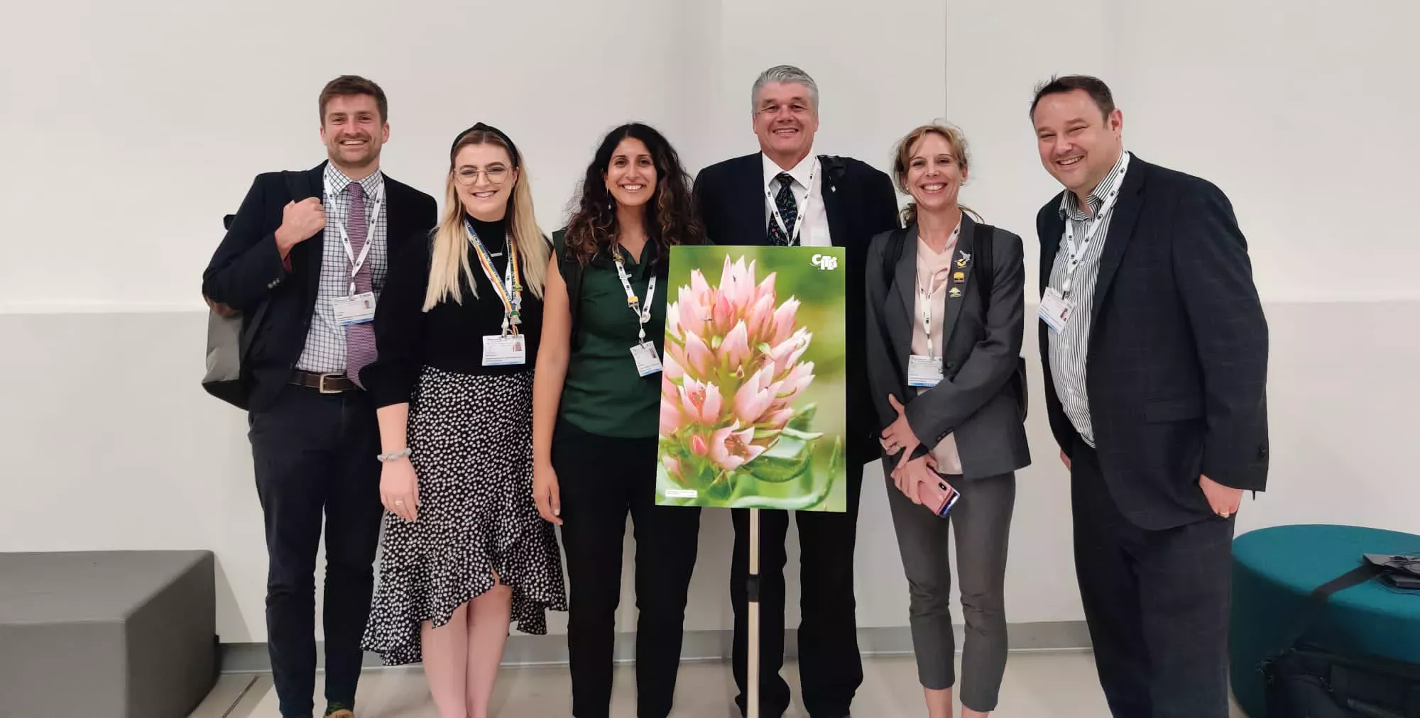 The Kew delegation with an image of a Rhodiola plant