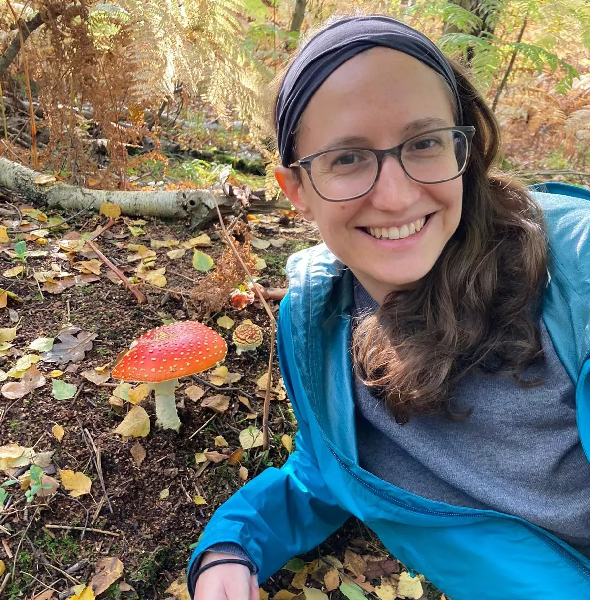 Rowena hill poses with a red mushroom coated in small white speckles