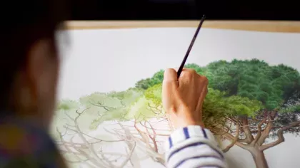 Close up of artist painting a tree on paper